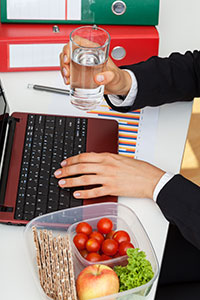 a man drinks a glass of water at work